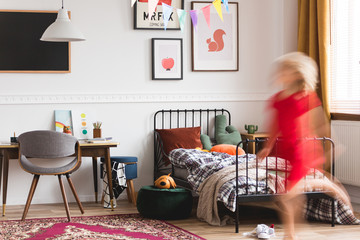 Unisex kids room with retro furniture, artworks and metal single bed