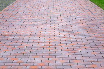 Red Paving slab, background. Pedestrian zone in the park in daylight. Stroll.