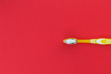 Toothbrush and toothpaste on a red background.