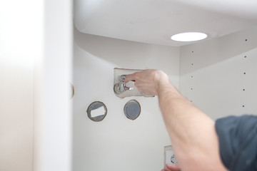 Naklejka premium Repair in bathroom at home. Plumber installing and setting new mixer tap. Hands worker close up. Outflow leakage.