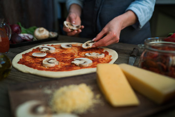 Obraz na płótnie Canvas Pizza art. The process of making pizza. Raw dough for pizza with ingredients and spices on table. Traditional Italian pizza and vegetables on a dark wooden background. Pizza menu. Soft focus.