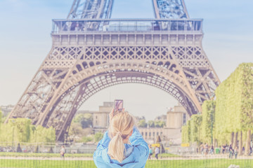 Girl taking pictures of Eiffel Tower.