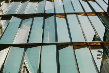 Obraz premium Glass window of a building with black aluminum frames, blue tone as background.