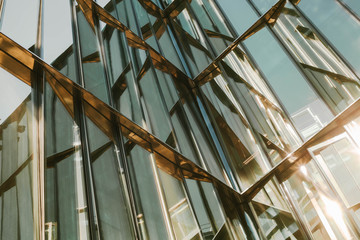 Glass window of a building with black aluminum frames, blue tone as background.