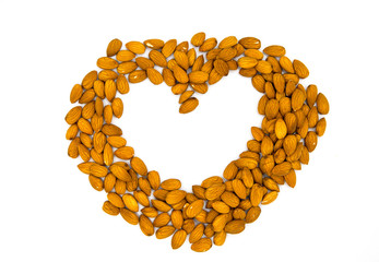 Heart frame from almond on white background. Love to natural food concept. Almond heart on white table top view photo