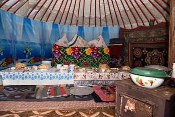 Interior of a yurt with stove and long table set for lunch guests