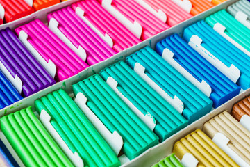 Rainbow colors of modeling clay. Multicolored plasticine bars ina box, background texture