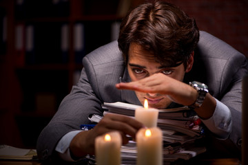 Businessman working late in office with candle light