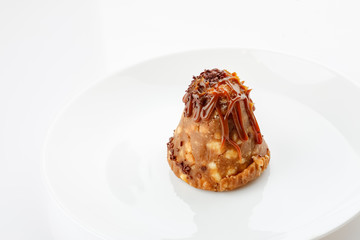 Small cake in plate on a white, closeup