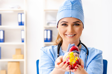 Young female doctor cardiologist sitting at the hospital 