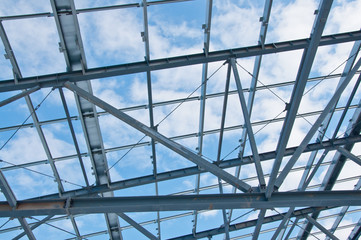 Metal frame of the new building against the blue sky with clouds
