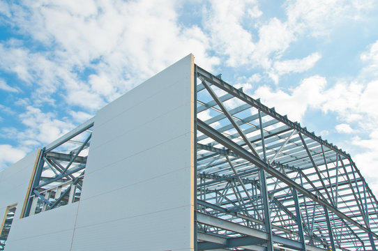 Metal Frame Of The Building With A Sandwich Panel Of Insulation On The Wall. Construction Of A New Industrial Building.