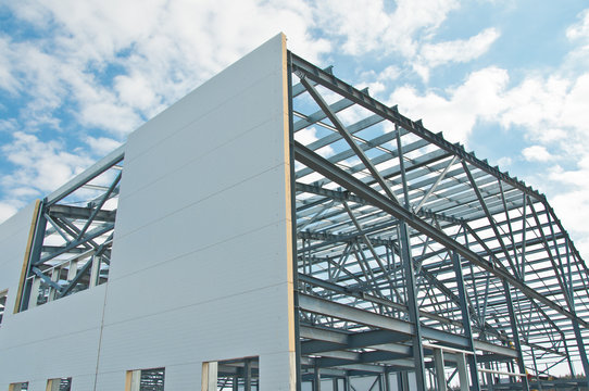 Metal frame of the building with a sandwich panel of insulation on the wall. Construction of a new industrial building. - Powered by Adobe