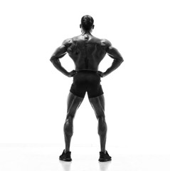 Fototapeta na wymiar Black and White image of Strong Muscular Men Flexing Muscles from the Back. He is showing back muscles development