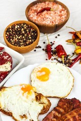 Fried egg and grilled bacon on kitchen table. Healthy breakfast. Protein for athletes.