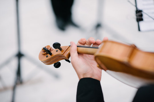 Musician playing violin with bow close up