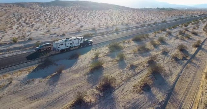 RV Fifth Wheel Driving On California Desert Road At Sunset - Side Aerial View Drone Shot