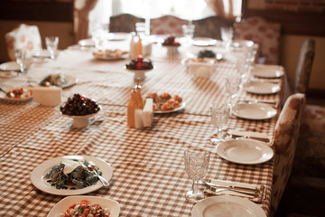 Close up view of table decoration in the Italian restaurant. Romantic evening atmosphere in europe. Tableware, food, flowers and wine glass.