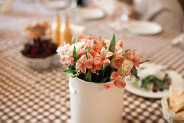 Close up view of table decoration in the Italian restaurant. Romantic evening atmosphere in europe. Tableware, food, flowers and wine glass.