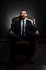 fine portrait of a white man with a beard in a business suit on a black background