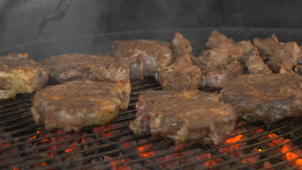 cuts of beef or pork are grilled for a party