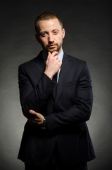 fine portrait of a white man with a beard in a business suit on a black background
