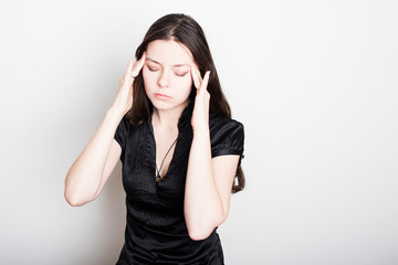 young woman is suffering from a headache. Portrait of a girl clutching her head. Migraines and blood pressure problems