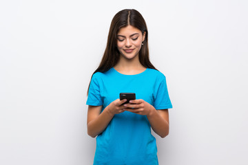 Teenager girl with blue shirt sending a message with the mobile