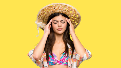 Teenager girl on summer vacation with headache over isolated yellow background