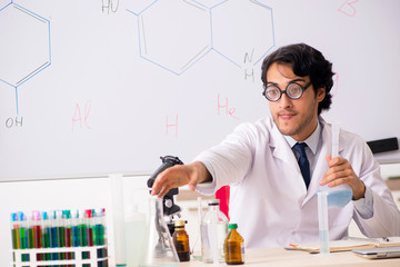 Young funny chemist in front of white board 