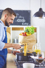 Smiling and confident chef standing in large kitchen