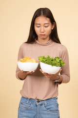 Young Asian woman with potato chips and salad.