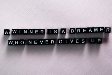 A winner is a dreamer who never gives up on wooden blocks. Motivation and inspiration concept