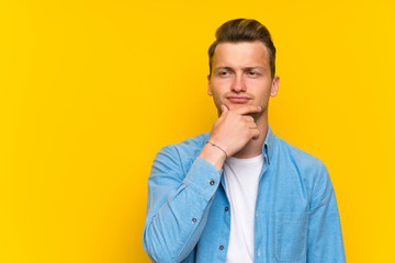 Blonde handsome man over isolated wall thinking an idea