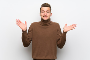 Fototapeta premium Blonde man over isolated white wall making unimportant gesture while lifting the shoulders