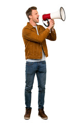 Blonde handsome man shouting through a megaphone