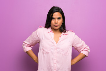 Fototapeta premium Young Colombian girl over purple wall angry