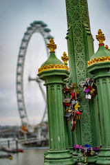 The electric pole at westminster bridge and london eye in background of green color
