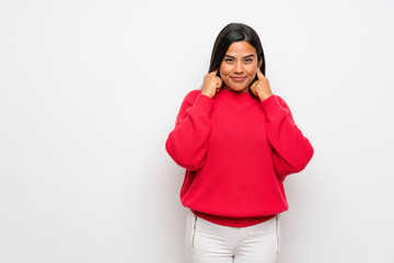 Young Colombian girl with red sweater frustrated and covering ears