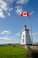 East Point Lighthouse PEI , with the Canadian flag in front of the light house