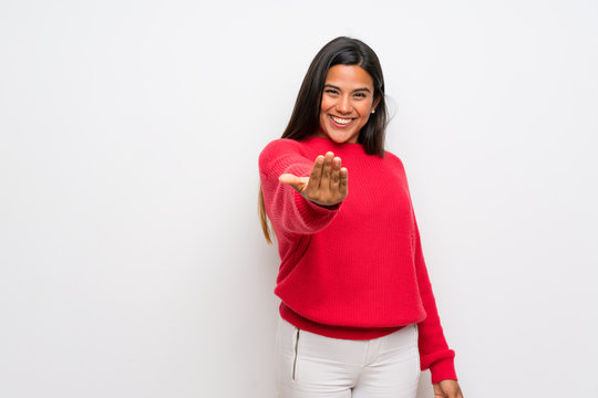 Young Colombian girl with red sweater inviting to come with hand. Happy that you came