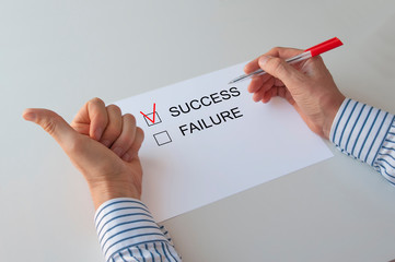 questionnaire,success and failure, the word success with a red check mark, pen in hand.