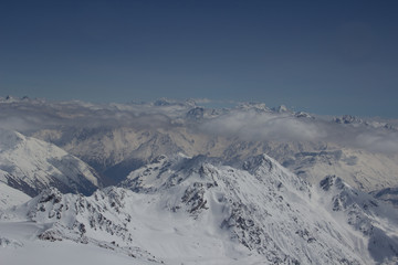 Fototapeta na wymiar Above the clouds. Snow Great Caucasus mountain range. Ushba on a Sunny winter's day. Kabardino-Balkaria, Russia