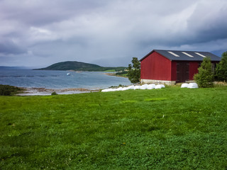 Fototapeta na wymiar Old red barn on the Norwegian fjord