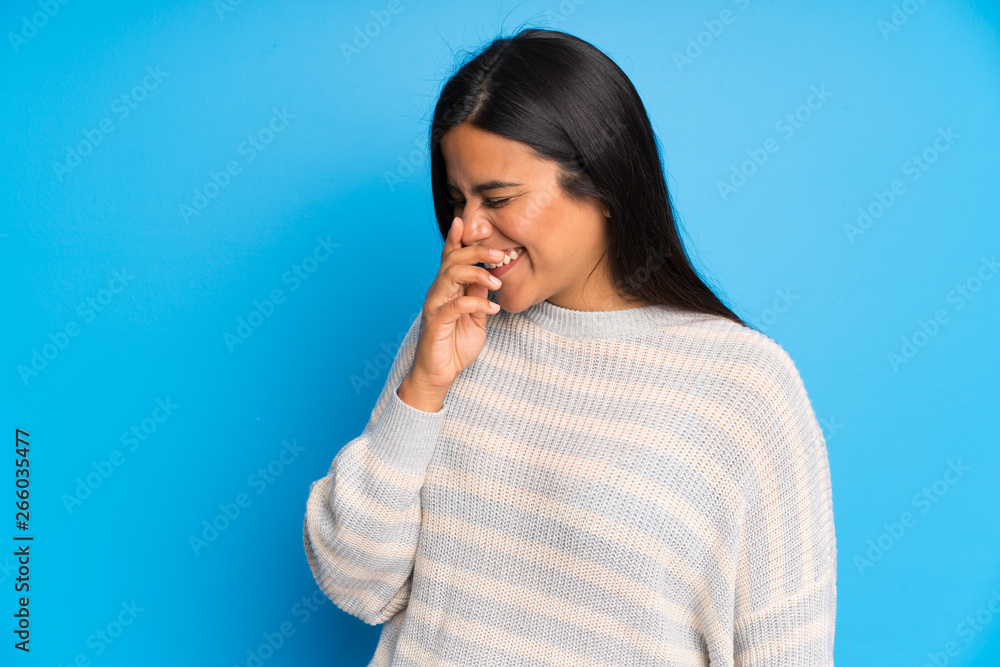 Wall mural Young Colombian girl with sweater laughing