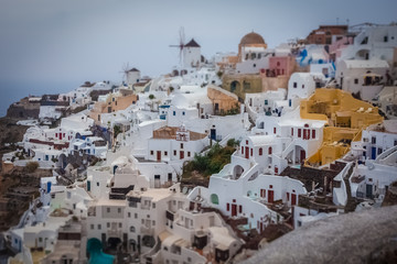 Fototapeta na wymiar Tilt shift effect of houses in the village of Oia on a cloudy day