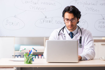 Young male doctor neurologist in front of whiteboard 