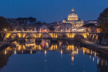 Tiber and St Peters Basilica with Aurelius Bridge or Ponte Sisto Bridge at the blue hour with lighting and reflections. Stone bridge over river Tiber in the historic center of Rome