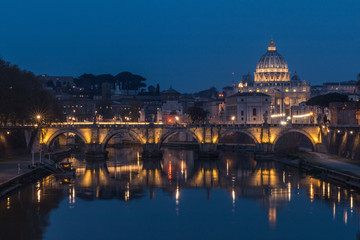 Obraz na płótnie Canvas Tiber and St Peters Basilica with Aurelius Bridge or Ponte Sisto Bridge at the blue hour with artificial lighting and reflections. Stone bridge at night over river Tiber in the historic center of Rome