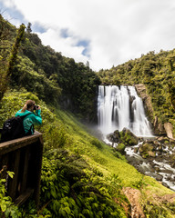 Traveler taking a picture of Marokopa Falls in New Zealand